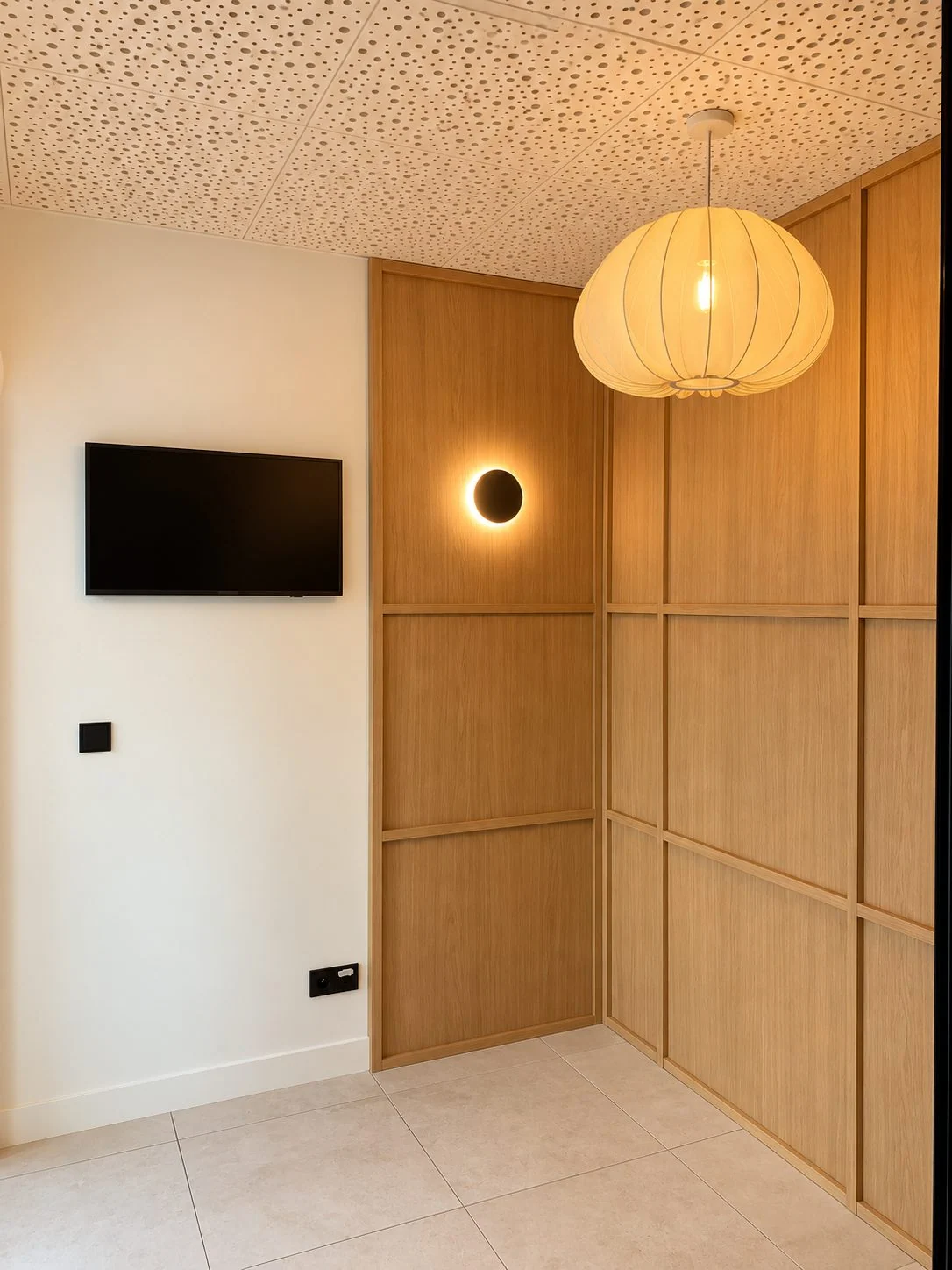 Panneaux de bois clair, luminaire suspendu et applique ronde